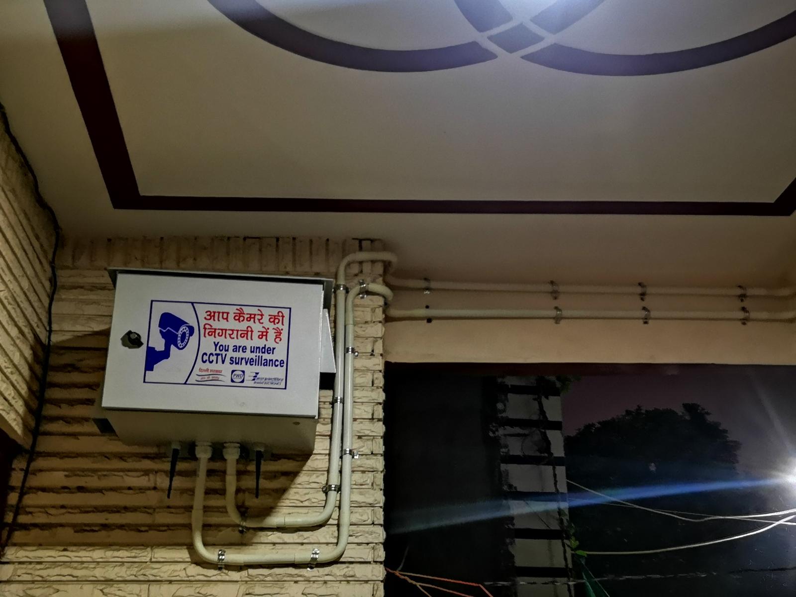 CCTV enclosure installed on a brick wall with neatly routed conduit lines running along the ceiling