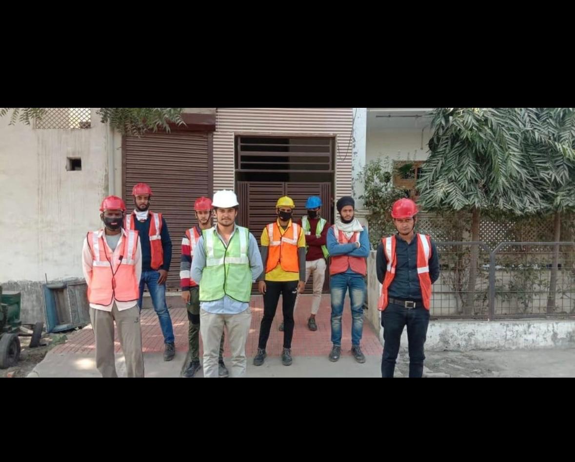 Installation team standing together in safety vests and helmets at a Karnal site