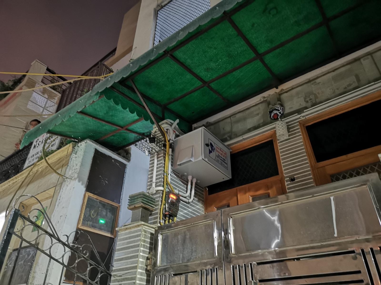 Installed CCTV equipment enclosure with power point and conduit beneath a canopy at a building entrance